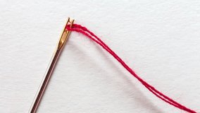 Video of metal needle for visually impaired people with special gold plated needle-eye and red thread on white background. New device for convenient sewing. Top view, close-up, flat lay, macro, mockup - Powered by Shutterstock - Get 15% off with code: PIKWIZARD15