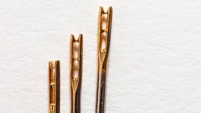Video of three metal needles for visually impaired people with a special gold-plated eye on a white background. Comfortable sewing and embroidery. Top view, copy space, flat lay, macro, closeup - Powered by Shutterstock - Get 15% off with code: PIKWIZARD15