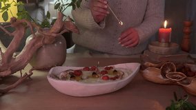 Close-up of a handmade aromatherapy candle burning gently in a ceramic bowl, decorated with dried flowers. Captured in dim natural light, the scene evokes a calm and cozy atmosphere. Perfect for theme - Powered by Shutterstock - Get 15% off with code: PIKWIZARD15