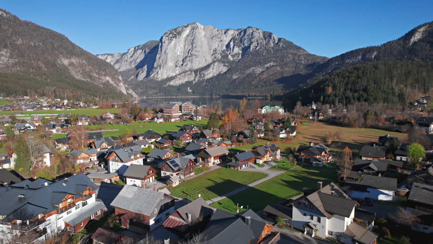 Aerial view of Altausseer See and village surrounded by mountains reflecting in calm alpine waters. Austria, Salzkammergut. 2x speeded up from 30 fps.
