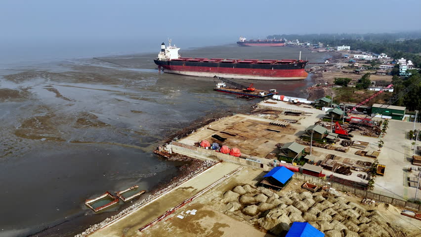 Cinematic epic revealing shot of a large ship graveyard in Bangladesh.