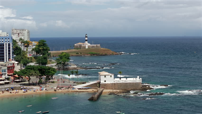 Aerial view of Barra neighbourhood with the historic Barra lighthouse and Santa Maria fort during summer in Salvador, Bahia, Brazil. 