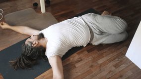 Man performing supta matsyendrasana yoga pose at home - Powered by Shutterstock - Get 15% off with code: PIKWIZARD15