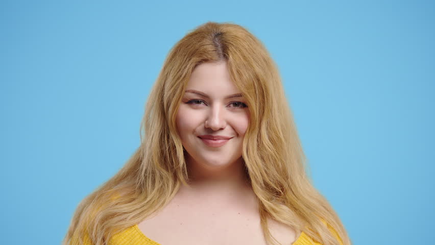 Real Curvy woman Showing Yes Signal, Nods Head, Approve. Positive on blue studio