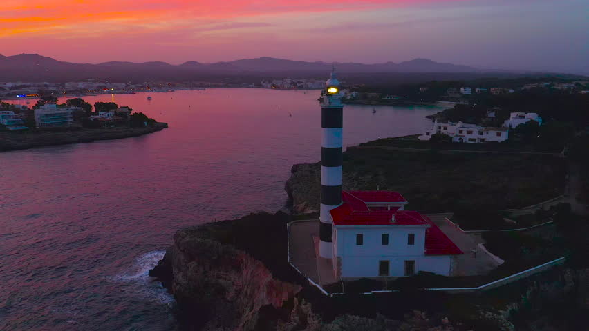 Aerial view of the Porto Colom lighthouse on the island of Mallorca, Spain, at sunset.