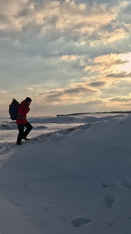 Hiker on top of hill at sunset. Expedition at dawn. Woman traveler tourist climbs snowy peak rejoices in his victory. Man traveler conquers fear overcomes difficulties. Sports recreation of climber