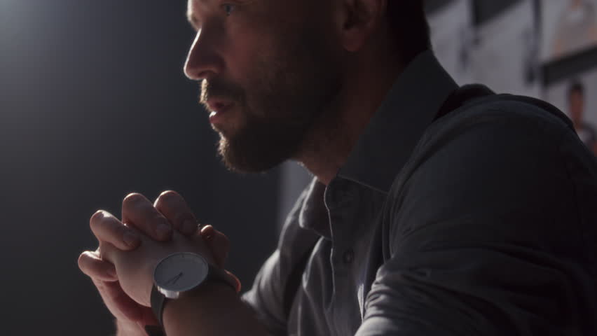 Angry officer pointing to suspect and delivering accusation during tense interrogation in police interview room