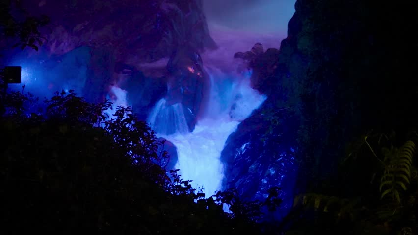 Purple light illuminates the Pailon del Diablo waterfall at night, Banos, Tungurahua, Ecuador