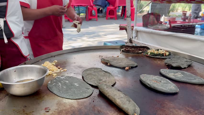 In the foreground, quesadillas are being prepared at a street stall in Mexico.