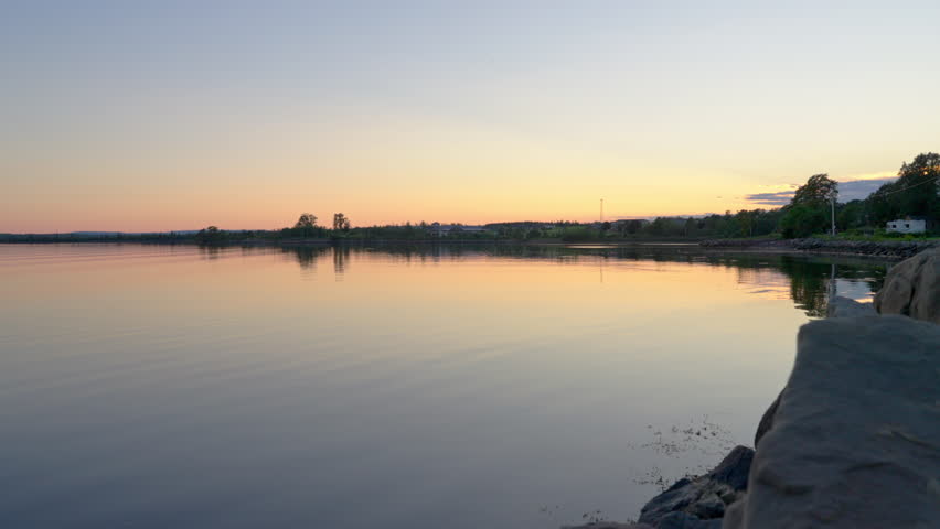 Serene sunset over ocean inlet in Nova Scotia with calm waves