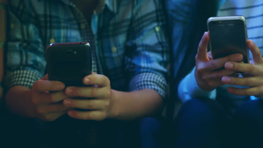 Third shifting in causing sliding market charts over friends phones showing data, tapping swiping. Technology, finance, trading, analytics, digital, casual, connectivity