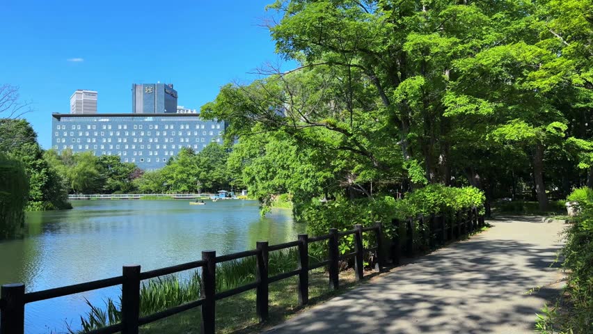 Scenic view of Sapporo Nakajima Park with a calm lake, walking path, and trees