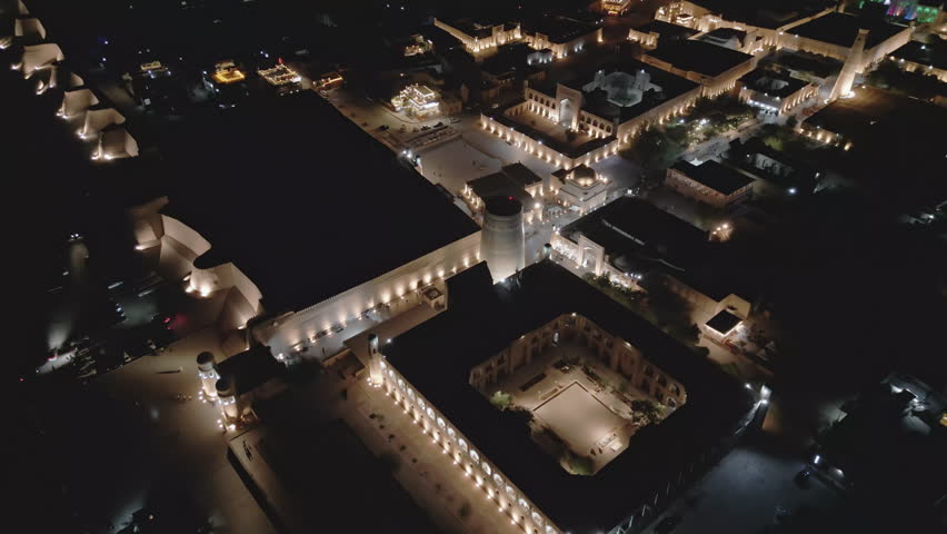 In this drone view, Khiva glows with lights tracing its outline. The city's legacy glimmers at night. A perfect blend of culture and architecture.