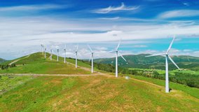 Aerial view of large white wind turbines with spinning blades on top of a mountain. Wind power generating self-sufficient, eco-friendly electricity on a beautiful sunny summer day. - Powered by Shutterstock - Get 15% off with code: PIKWIZARD15