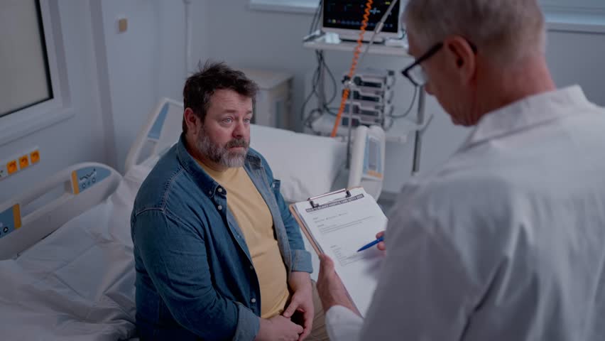 Doctor explaining the risks of leaving the hospital early as the patient prepares to sign an AMA form.
