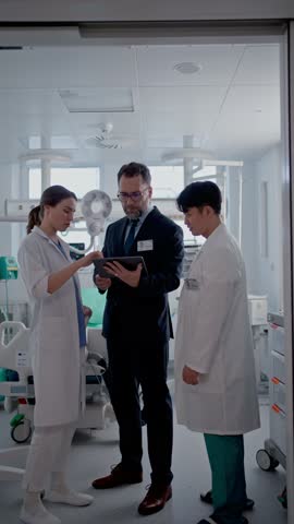 Pharmaceutical sales respresentatives showing doctor new medications. Group presentation in hospital setting.