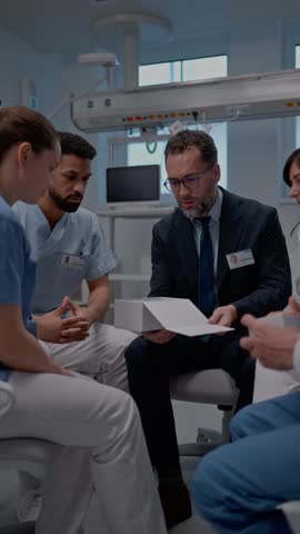 Pharmaceutical sales respresentative showing medical staff new medications. Group presentation in hospital setting.