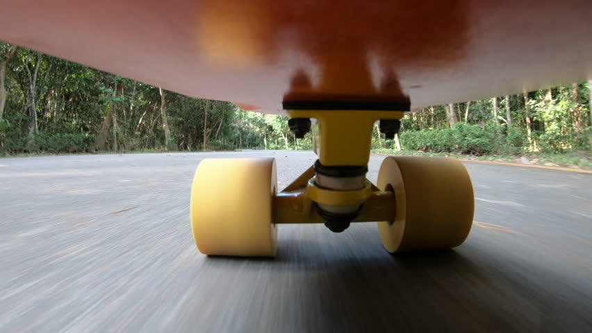 Skateboarders riding skateboard on forest road,Under skateboard POV