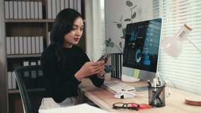 Professional businesswoman analyzing smartphone data while reviewing financial graphs on computer display - Powered by Shutterstock - Get 15% off with code: PIKWIZARD15