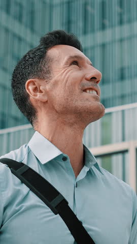 Hopeful businessman looking up in the business district, thinking about future ambition and aspirations
