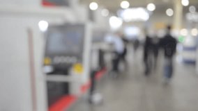 People walking in building with machines and equipment with control panels. Building with walls, floor, ceiling illuminated lamps. Silhouettes of people indoors. Blue color. Blurred background. - Powered by Shutterstock - Get 15% off with code: PIKWIZARD15