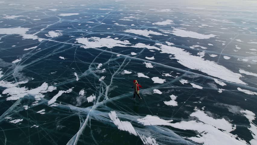 Skater tourist woman gliding over frozen lake Baikal