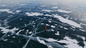 Skater tourist woman gliding over frozen lake Baikal's cracked ice surface in Russia's stunning winter landscape. - Powered by Shutterstock - Get 15% off with code: PIKWIZARD15