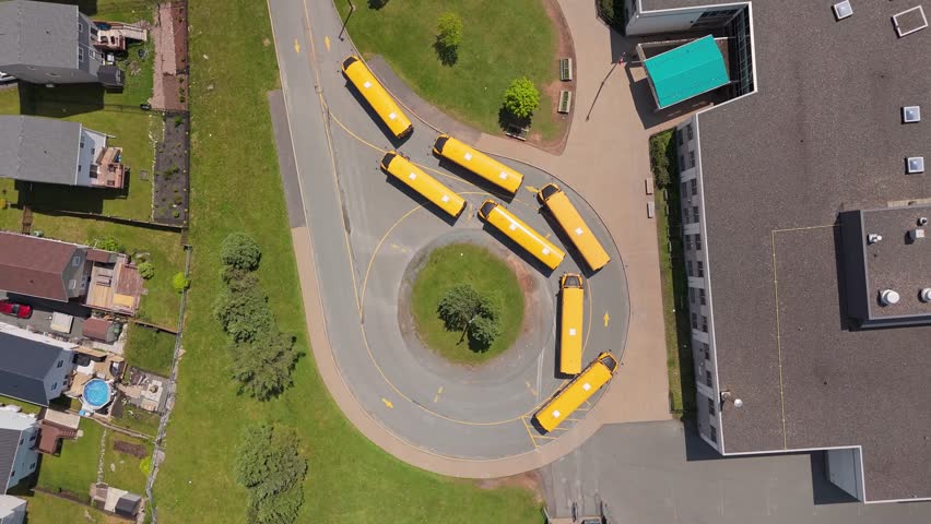 Top View School Buses Are Parked In A Circular Formation Near The School Entrance, Ready To Take Students Home. The Scene Is Captured From Above On A Warm, Sunny Day In Halifax, Nova Scotia.