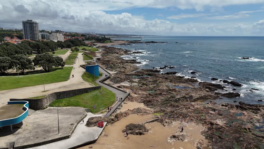4K Aerial Drone Footage of Coastal Cityscape with Ocean Waves, Beachfront Promenade, Urban Architecture, and Waterfront Captured in Daylight