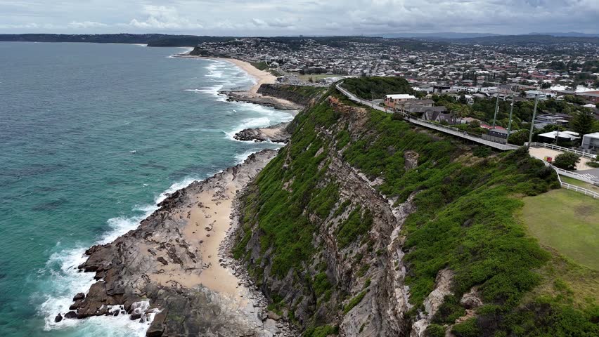 Newcastle NSW Australia Rocky Coastline Coastal Cliffside Overlooking the Ocean with Urban Skyline in the Distance. Shepherds Hill, the Hawkesbury Sandstone deposit on which Newcastle was built