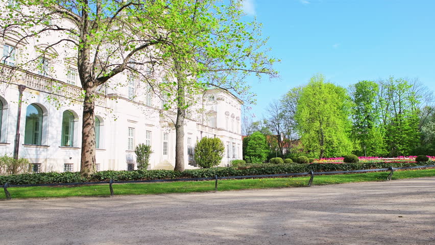 Krasinski park garden Warsaw, Poland in spring with landscaped flowers bed lawn, green grass by palace building exterior