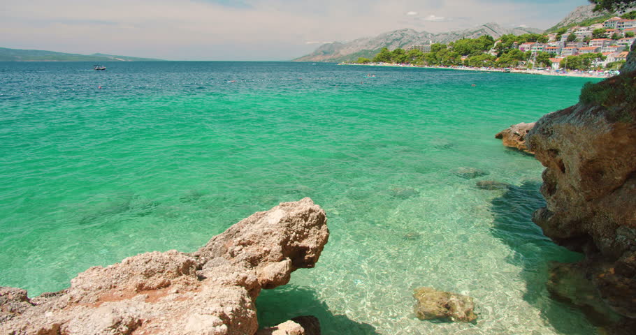 Rocky coast and green blue water near a seaside town in summer Croatia