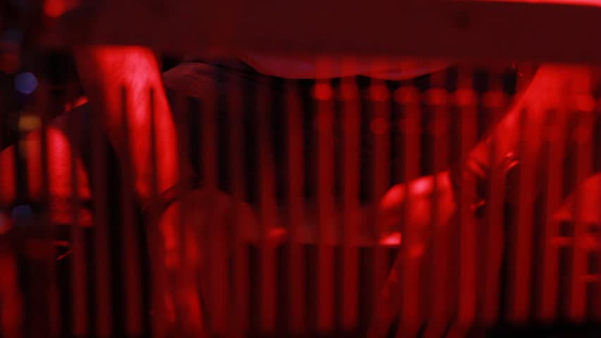 Close-up of hands dynamically drumming a drum. The rhythmic percussion is illuminated by dramatic red lighting, perfect for capturing energetic musical performances 