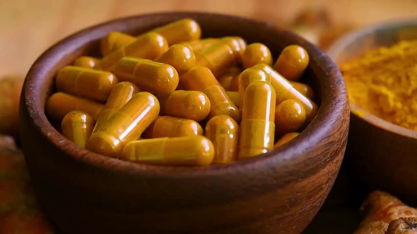 Natural Turmeric Capsules in a Wooden Container - Herbal Supplements
