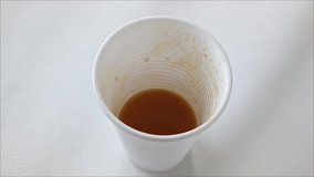 Fresh juice is poured into a plastic cup on a white background. The use of disposable cups. - Powered by Shutterstock - Get 15% off with code: PIKWIZARD15