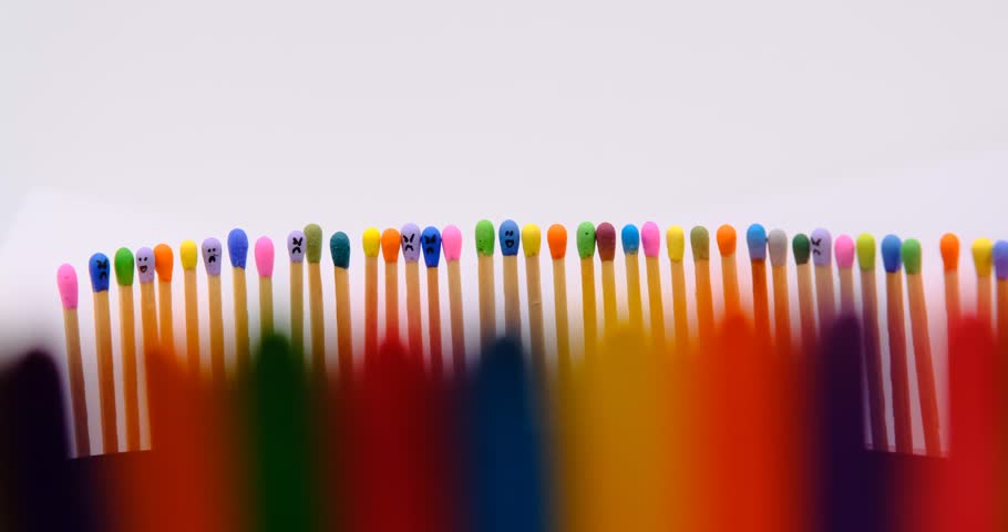 multicolored match sticks in rotation on a rotating table with white background, close up view, full screen