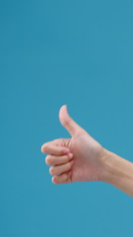 Vertical Screen : Young woman hand showing thumb up sign with fingers isolated over blue background in studio. Copy space for place text, message for advertisement. Advertising area, mock up content.