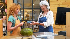 Experienced senior greengrocer carefully weighing fresh melon for young customer at vibrant outdoor market stall, exemplifying friendly local retail interaction - Powered by Shutterstock - Get 15% off with code: PIKWIZARD15