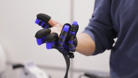 Man wearing advanced robotic exoskeleton glove. Close-up of a person testing a high-tech robotic glove designed for rehabilitation, VR interaction, or enhanced hand movement assistance. - Powered by Shutterstock - Get 15% off with code: PIKWIZARD15