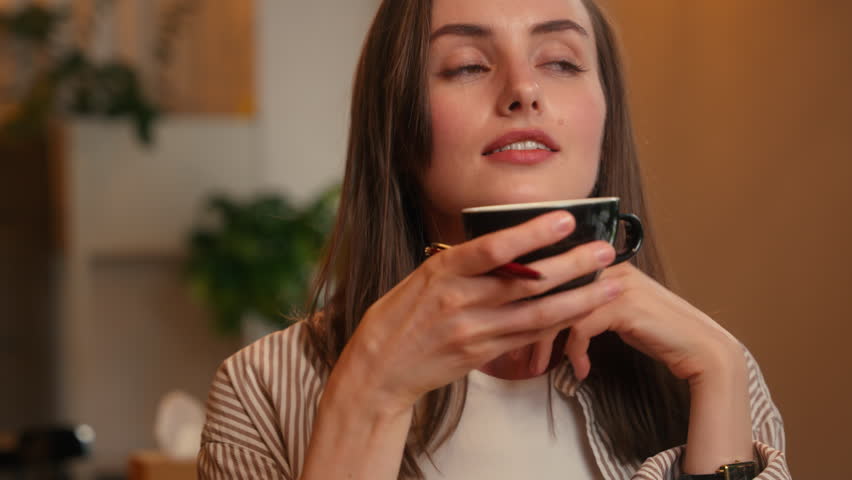 Caucasian woman sitting in cafe female girl writing notes in notebook write idea plan noting schedule drinking tea enjoy coffee thinking dreaming inspiration sit at table in cafeteria working distant
