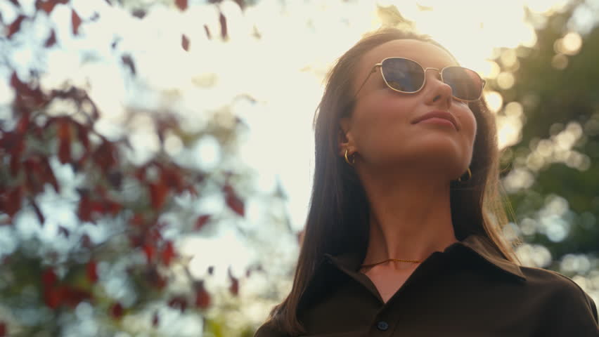 Stylish happy Caucasian woman put on dark glasses wearing sunglasses businesswoman female girl at street autumn city looking around enjoying weather healthy cheerful smiling outdoors fashion style