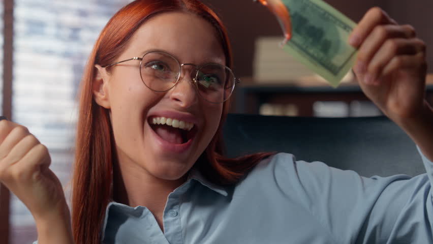 Close up European rich crazy funny happy smiling business woman businesswoman female girl investment in office burning money dollar laughing having fun joy banknote fire flame cash financial crisis