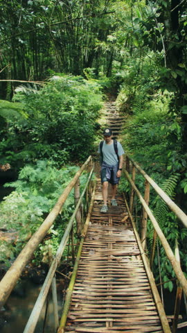 Traveler walking on bamboo bridge in Bali jungle
