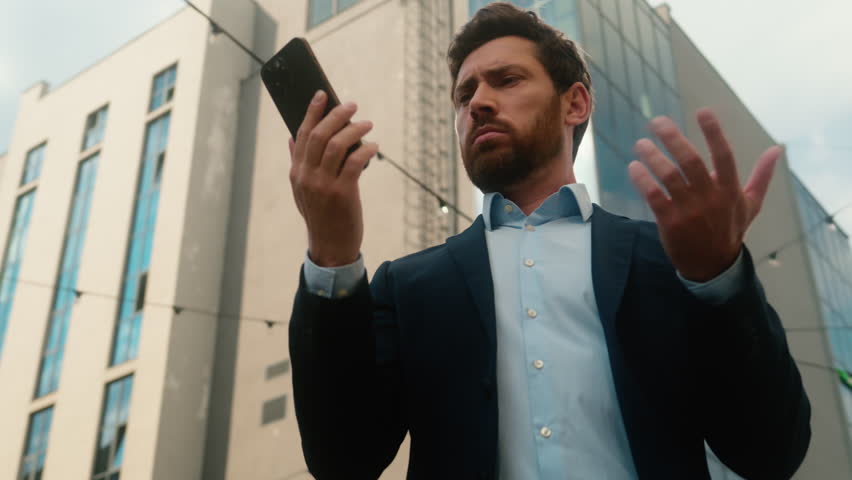 Caucasian middle-aged businessman adult business man male guy entrepreneur angry irritated trying call with mobile phone failure connection error Wi-Fi lost broken smartphone bad signal in sunny city