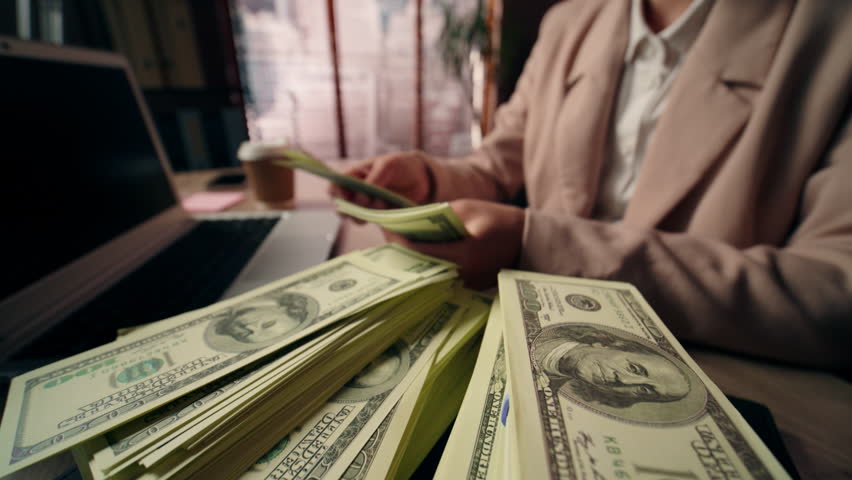 Close up unrecognizable Caucasian business woman female freelancer girl rich successful businesswoman wealthy accountant winner counting money cash wage dollars salary laptop device prize win office