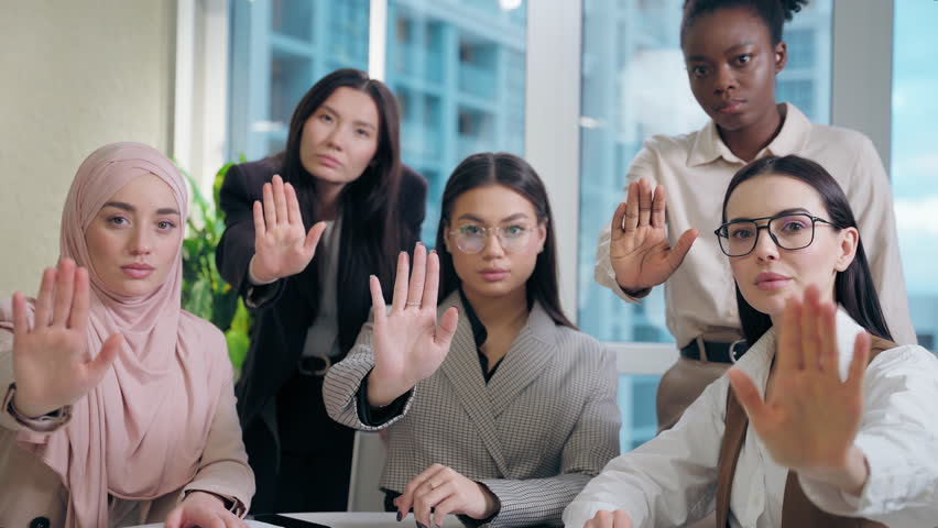 Strong serious multiethnic women females team girls African American Caucasian Japanese Muslim hijab Arabian businesswomen looking camera showing palm gesture no deny refuse stop office meeting room