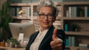 Caucasian smiling old business woman pointing hey you looking at camera showing thumb up like in office mature businesswoman female support success work good result approve choosing with index finger - Powered by Shutterstock - Get 15% off with code: PIKWIZARD15