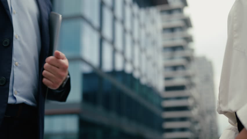 Close up business handshake two unrecognizable multiracial diversity people in city handshaking hands gestures talking African American businesswoman woman female Caucasian man businessman male deal