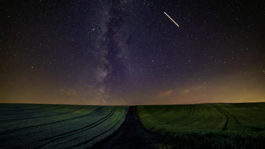 A mesmerizing scene of a Milky Way galaxy as seen from Earth over green fields at night