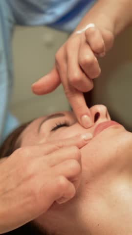 Chic woman having skin treatment done by beautician, vertical orientation. Well-being, medical aid, wrinkle prevention, health, doctor services, skin rejuvenation treatment. Hydrated glowing skincare